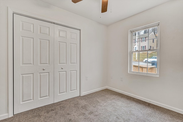 unfurnished bedroom with ceiling fan, a closet, and carpet