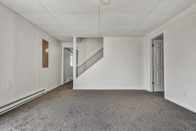 basement featuring a baseboard radiator, electric panel, a drop ceiling, and dark colored carpet