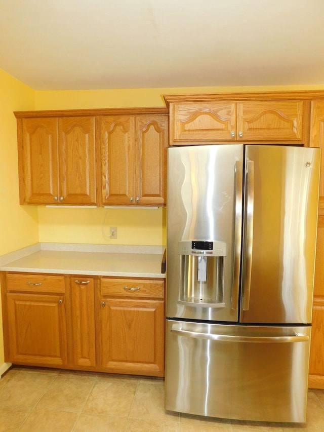 kitchen featuring stainless steel fridge with ice dispenser and light tile patterned floors