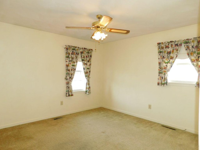 spare room featuring light carpet and ceiling fan