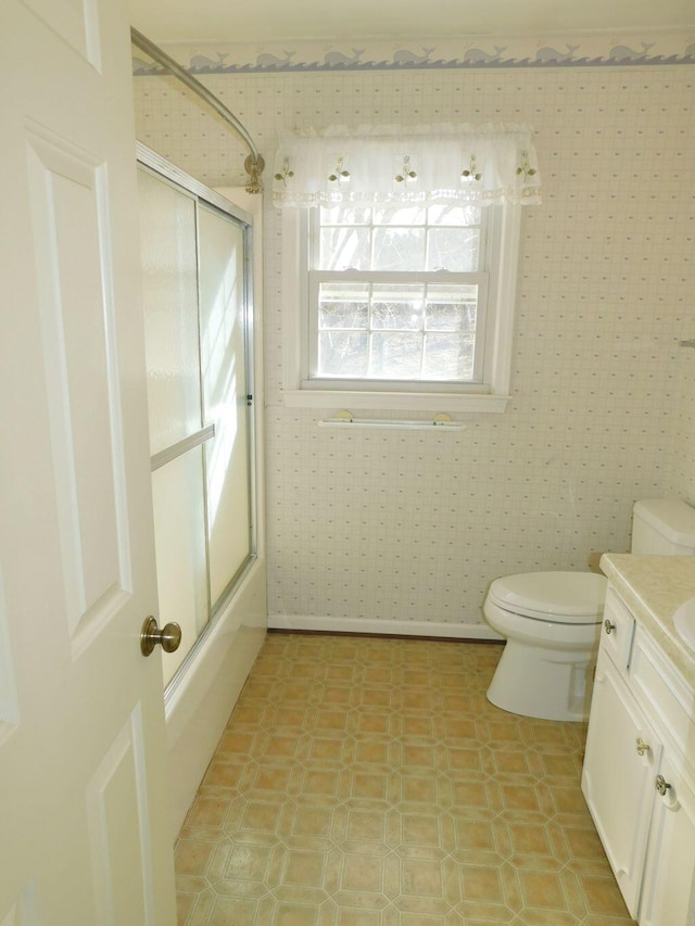 full bathroom featuring bath / shower combo with glass door, vanity, and toilet