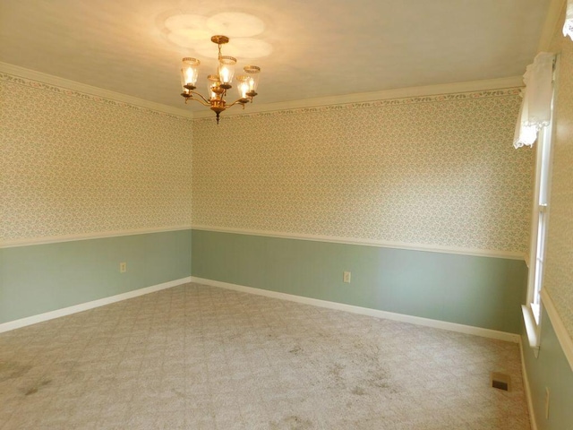 unfurnished room featuring an inviting chandelier, carpet floors, and ornamental molding