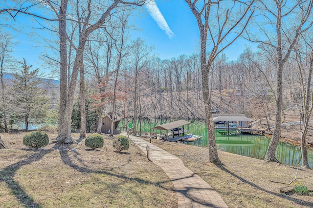 view of yard featuring a boat dock and a water view