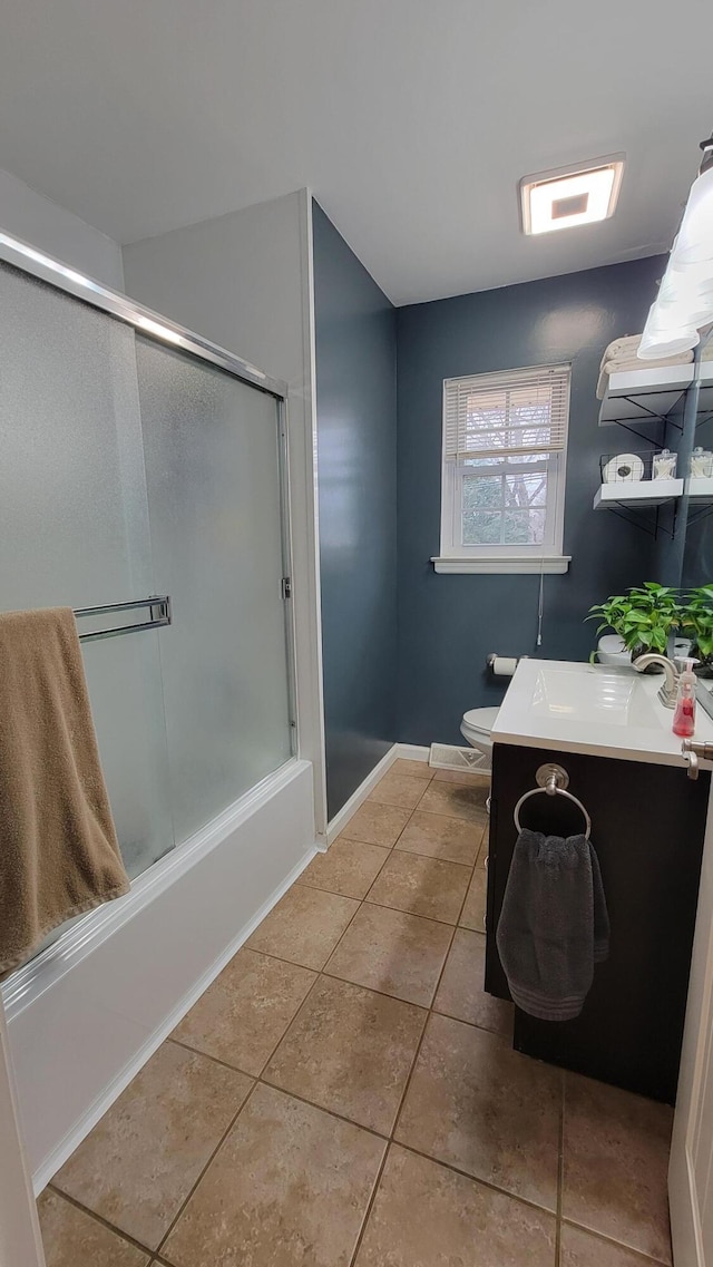 full bathroom featuring bath / shower combo with glass door, tile patterned floors, toilet, and vanity