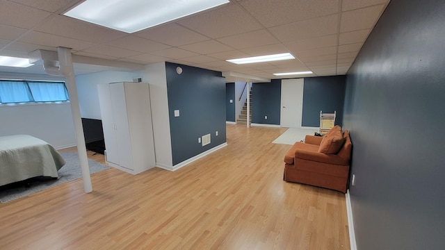 interior space featuring a drop ceiling and hardwood / wood-style floors