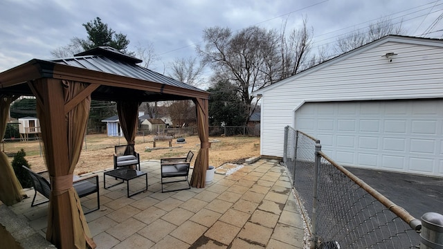 view of patio featuring an outbuilding, a garage, and a gazebo