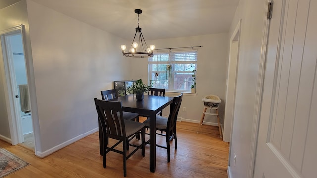 dining room with a notable chandelier and light wood-type flooring