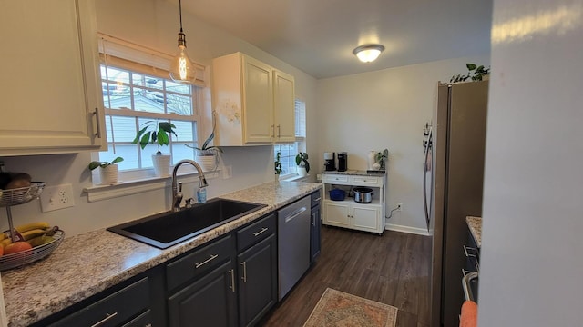 kitchen with sink, white cabinetry, hanging light fixtures, appliances with stainless steel finishes, and dark hardwood / wood-style floors