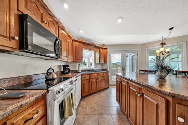 kitchen featuring french doors, brown cabinets, dark countertops, hanging light fixtures, and white appliances