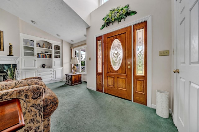 carpeted foyer entrance featuring lofted ceiling, a premium fireplace, baseboards, and a textured ceiling