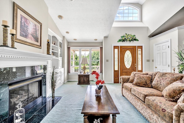 living area with plenty of natural light, a fireplace, dark carpet, and a textured ceiling