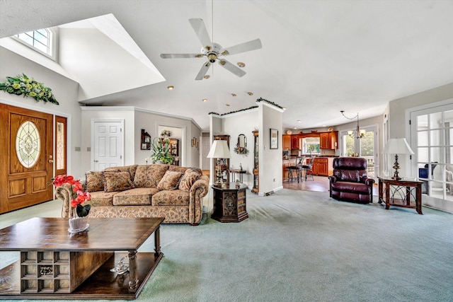 living area with light carpet, a high ceiling, and ceiling fan with notable chandelier