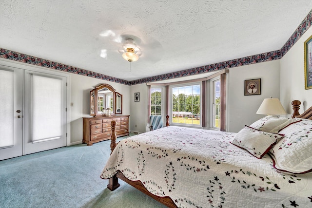 carpeted bedroom with access to exterior, baseboards, a textured ceiling, and french doors