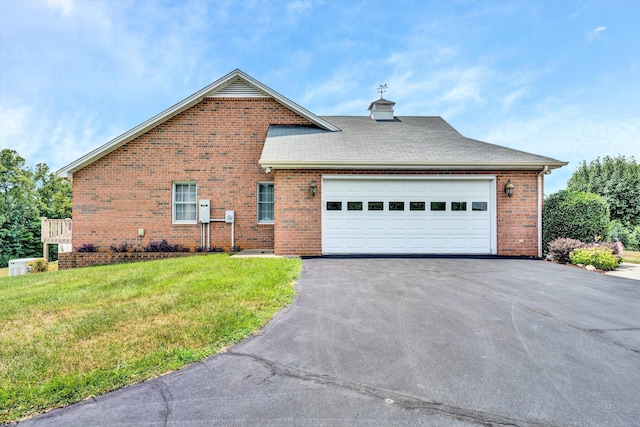 view of front facade featuring brick siding, roof with shingles, a garage, driveway, and a front lawn