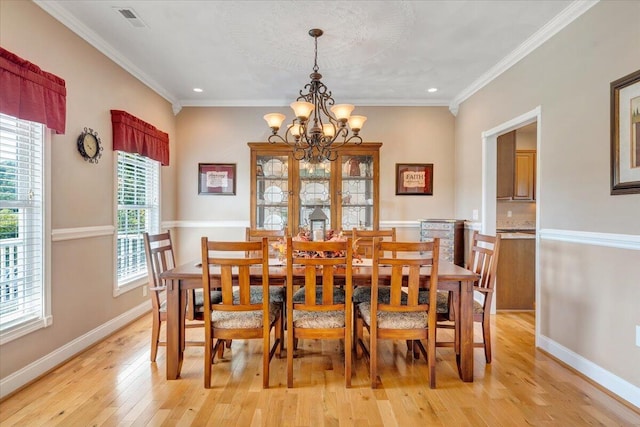 dining area featuring an inviting chandelier, light hardwood / wood-style flooring, and ornamental molding