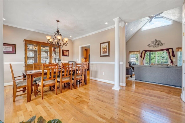 dining area featuring an inviting chandelier, light hardwood / wood-style flooring, ornamental molding, and ornate columns