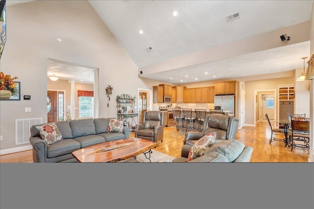 living room featuring ornate columns, high vaulted ceiling, and light hardwood / wood-style floors