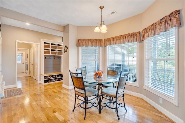 dining space featuring a notable chandelier and light hardwood / wood-style floors