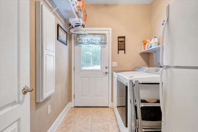 clothes washing area with independent washer and dryer and light tile patterned floors