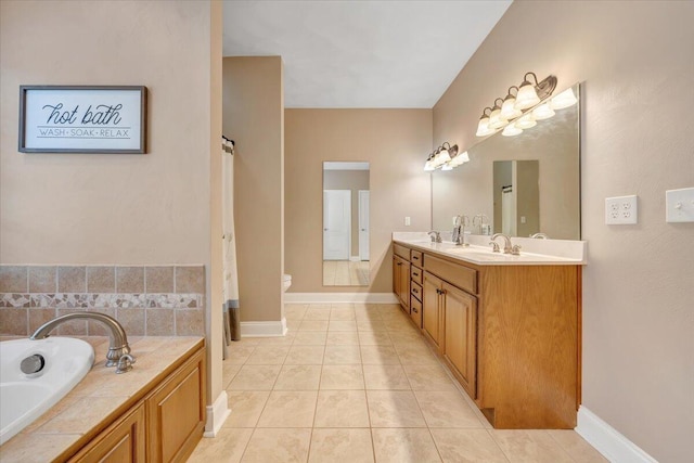 bathroom with tile patterned floors, toilet, vanity, and a tub