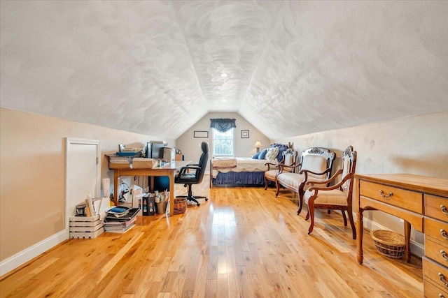 office with hardwood / wood-style flooring, vaulted ceiling, and a textured ceiling