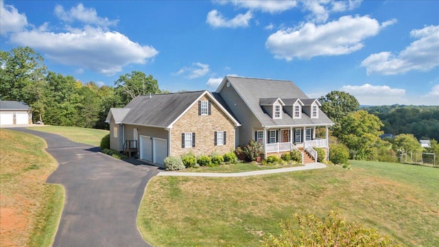 new england style home with a porch, a garage, and a front yard