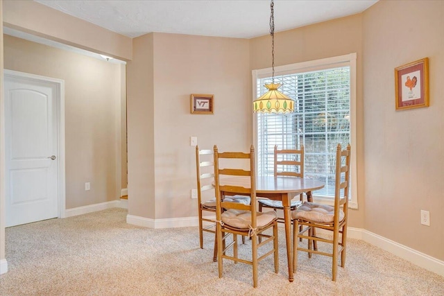 dining area featuring light carpet