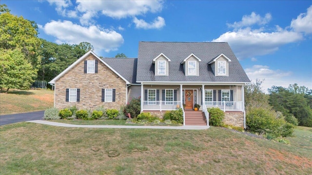 new england style home featuring a front yard and covered porch