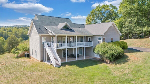 back of property featuring a wooden deck, a yard, and a patio