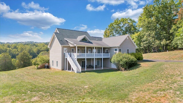 rear view of property featuring a wooden deck, a yard, central AC, and a patio area