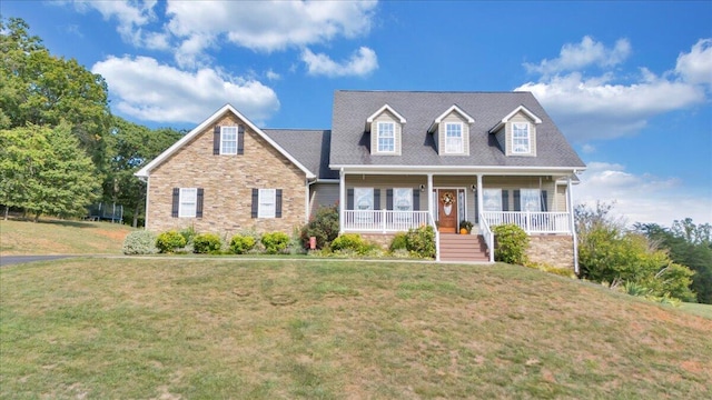 new england style home with covered porch and a front yard