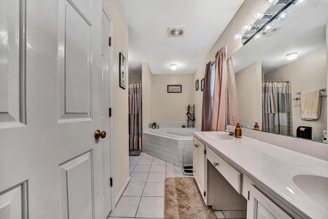 bathroom featuring a relaxing tiled tub, vanity, and tile patterned flooring