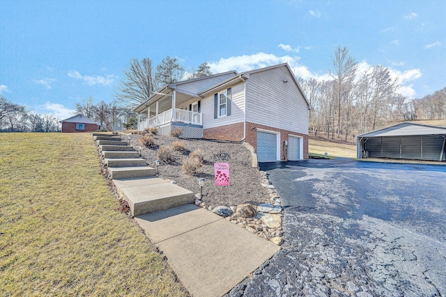 view of side of property with a garage, a yard, a carport, and a porch