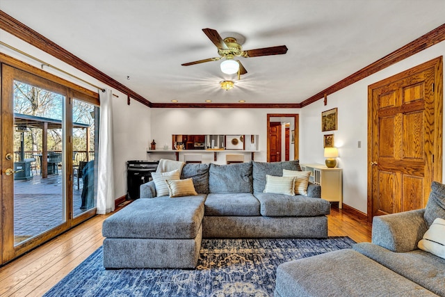 living room with hardwood / wood-style flooring, crown molding, and ceiling fan