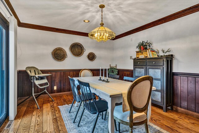 living room with hardwood / wood-style flooring, ornamental molding, a brick fireplace, and built in features