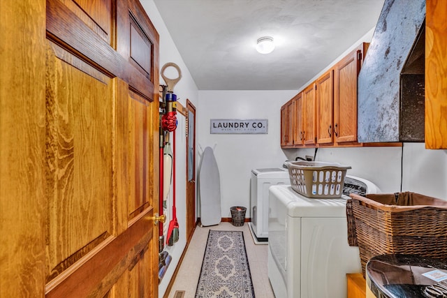 laundry area with washer and clothes dryer and cabinets