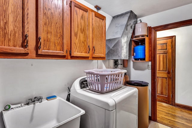 washroom featuring washer / clothes dryer, sink, and cabinets