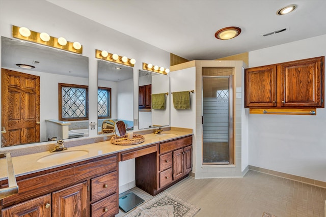 bathroom featuring tile patterned floors, vanity, and a shower with shower door