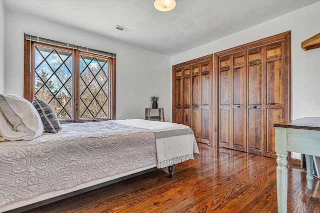 bedroom featuring multiple closets and dark hardwood / wood-style flooring