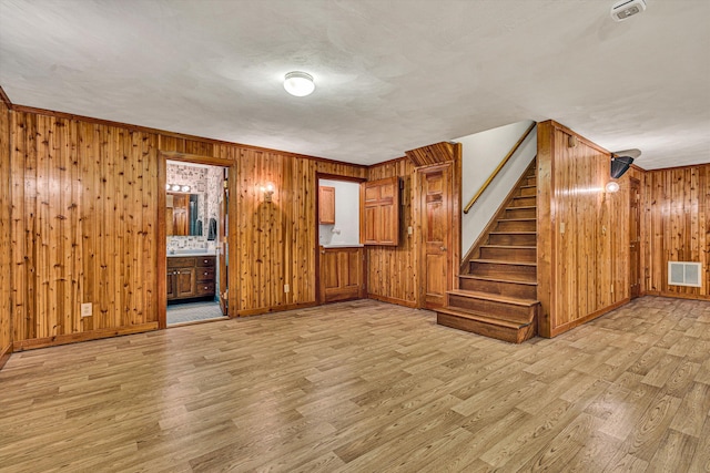 interior space with wooden walls and light hardwood / wood-style floors