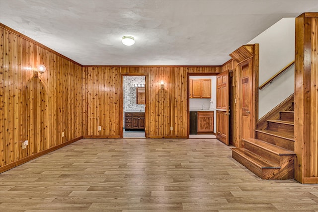 unfurnished living room featuring wooden walls and light wood-type flooring