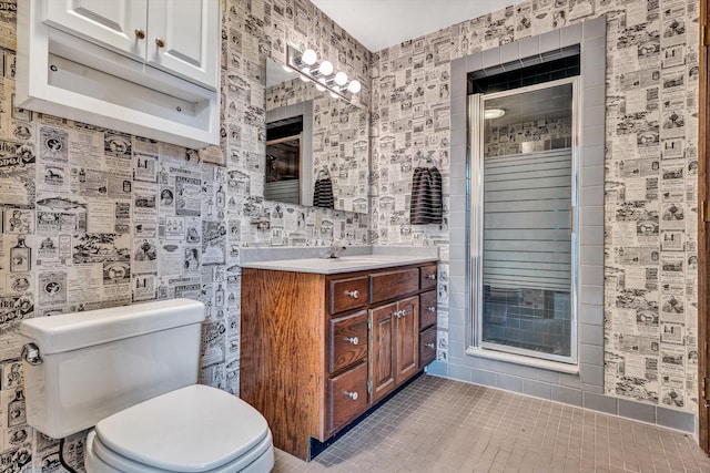 bathroom featuring vanity, toilet, an enclosed shower, and tile patterned flooring