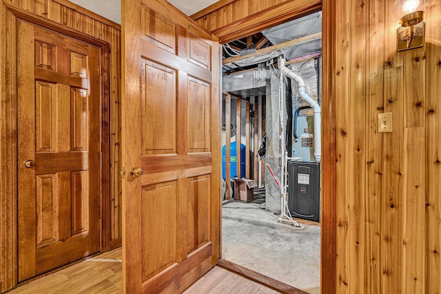 corridor featuring light hardwood / wood-style flooring and wooden walls