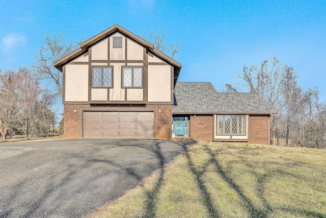 tudor house featuring a garage and a front yard