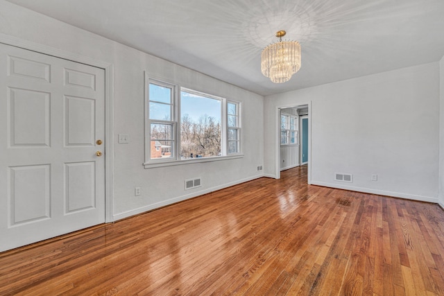 interior space with a notable chandelier and light hardwood / wood-style flooring