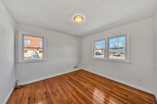 spare room featuring hardwood / wood-style floors and a healthy amount of sunlight