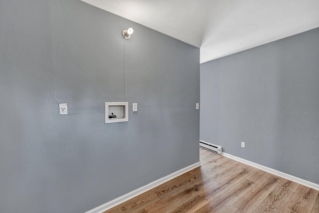 washroom featuring hookup for a washing machine, a baseboard radiator, and light hardwood / wood-style floors