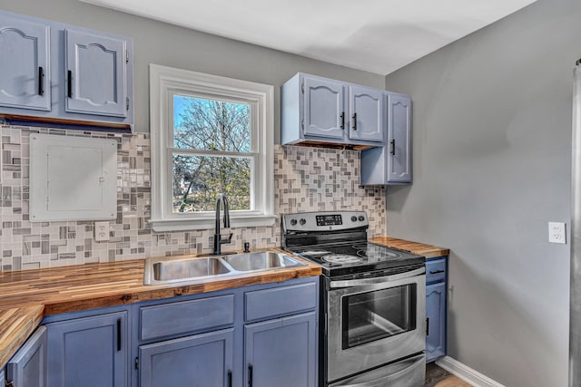 kitchen featuring blue cabinets, butcher block counters, sink, stainless steel range with electric stovetop, and decorative backsplash