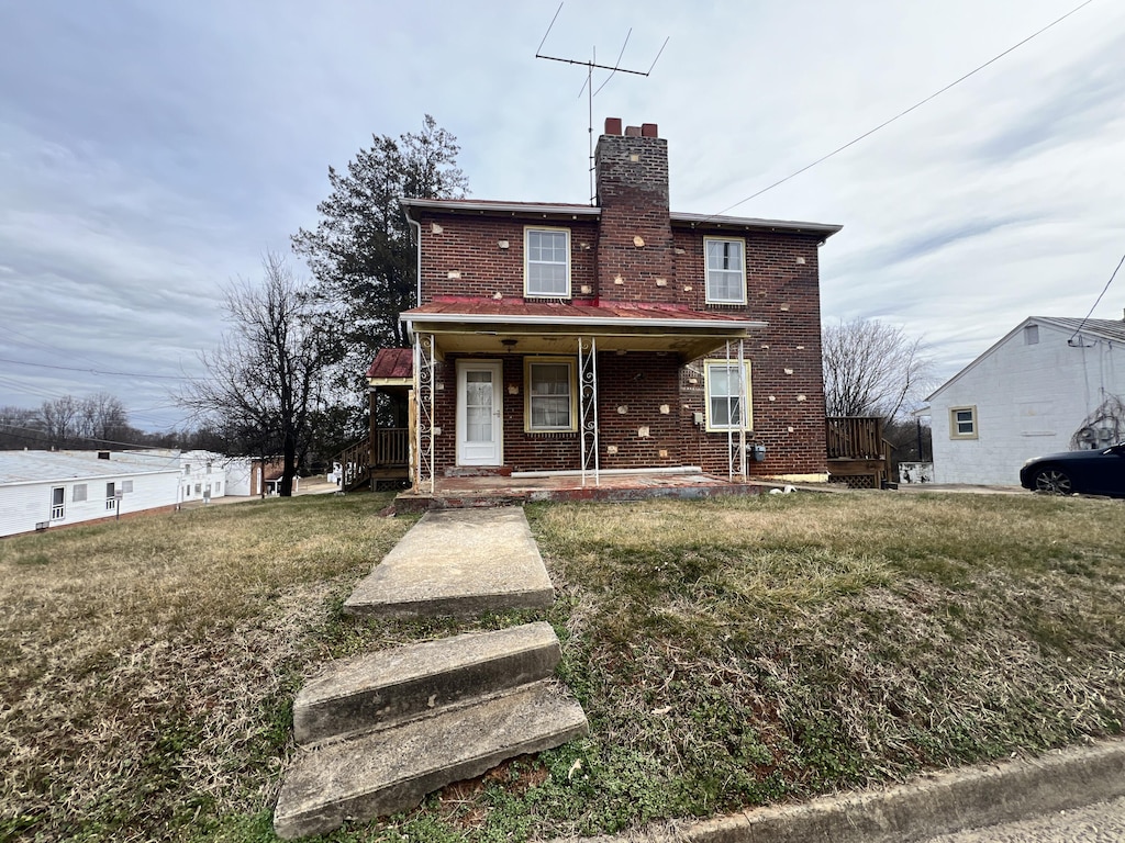 rear view of house with a yard and a porch