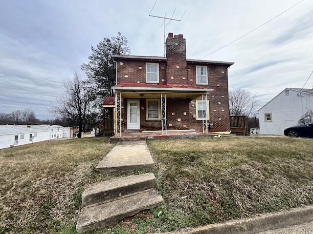 back of house featuring a lawn and covered porch